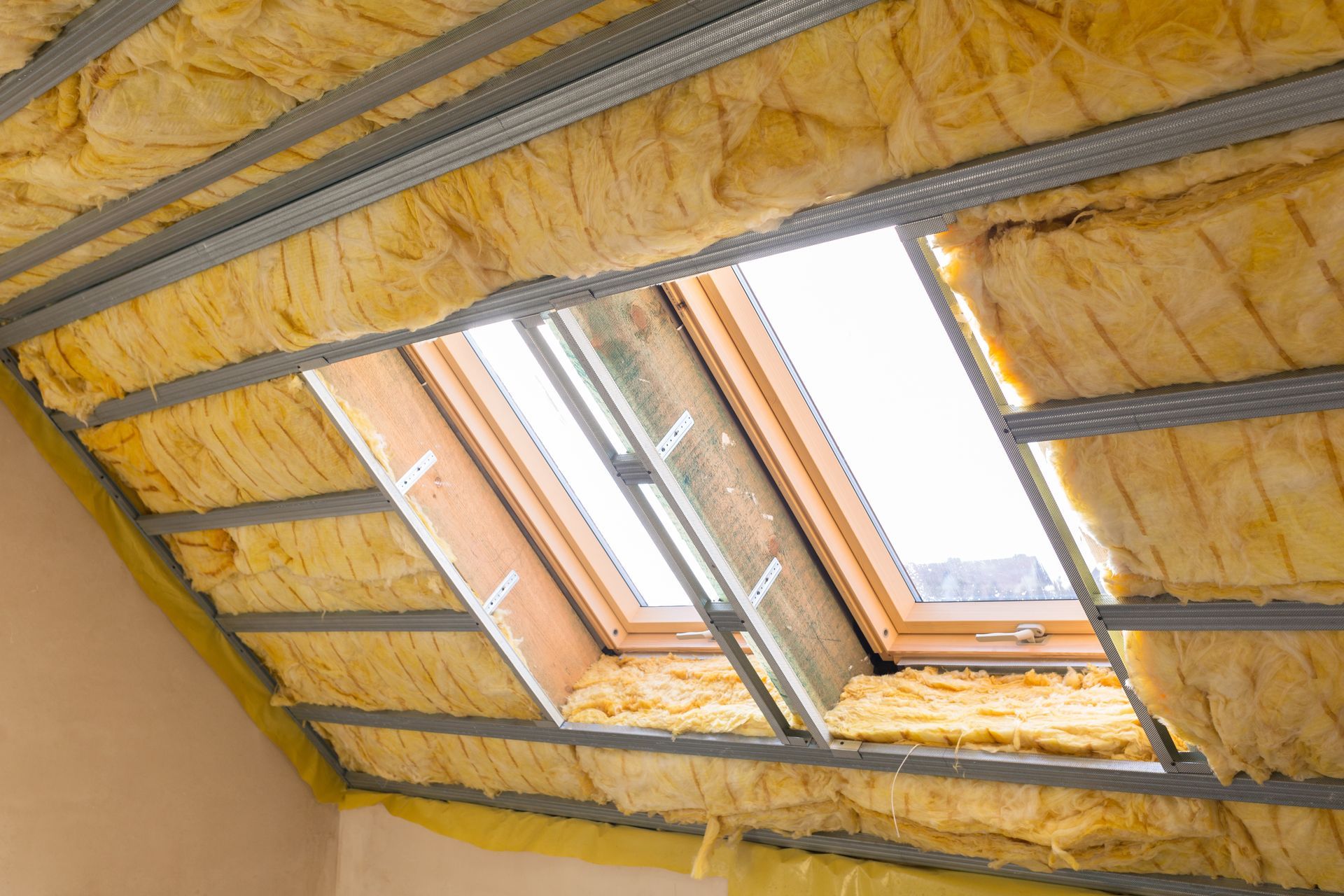 Insulated attic roof with a skylight window and exposed wooden framing