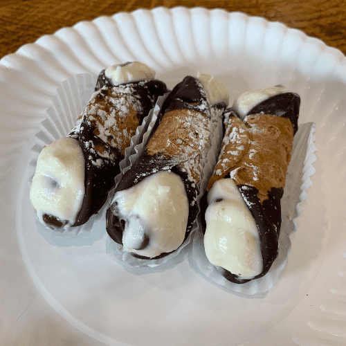 3 chocolate dipped cannolis on a plate from Agata and Valentina in New York City