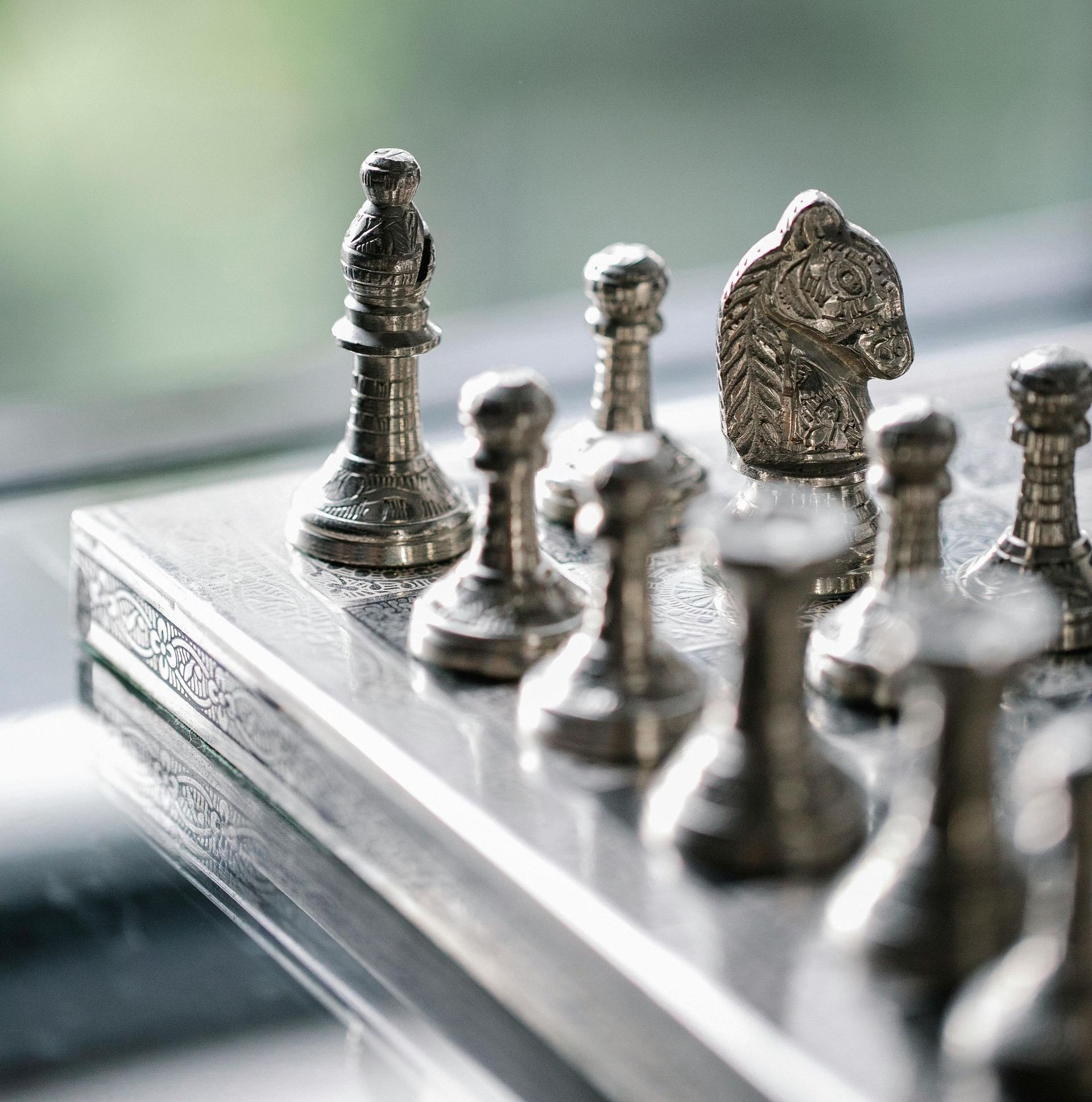 Metal chess pieces on a chessboard in Washington Square Park