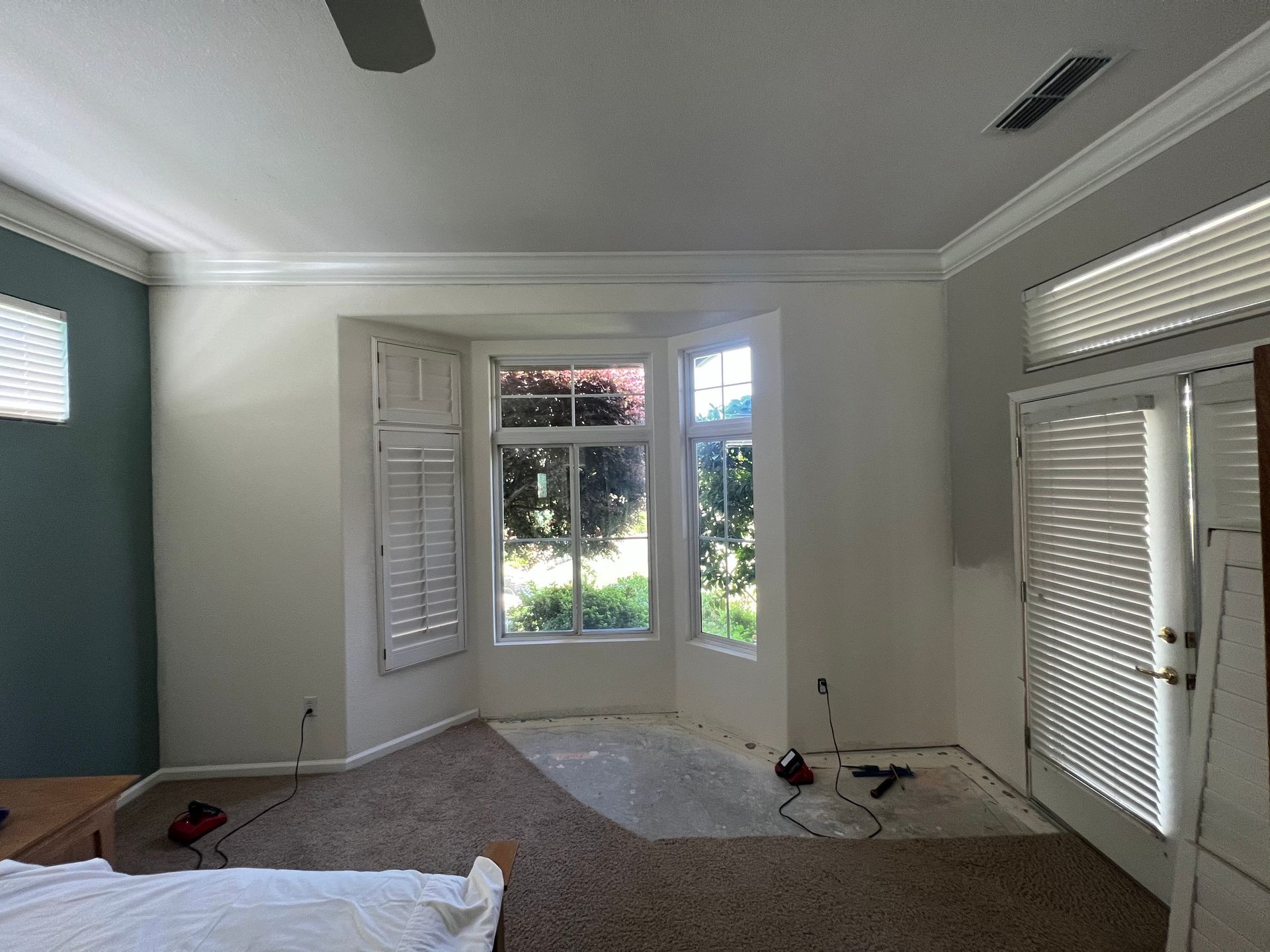 A bedroom with a bed and a ceiling fan