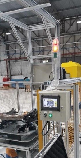 Uma máquina está sendo construída em uma fábrica com uma luz vermelha em cima dela.