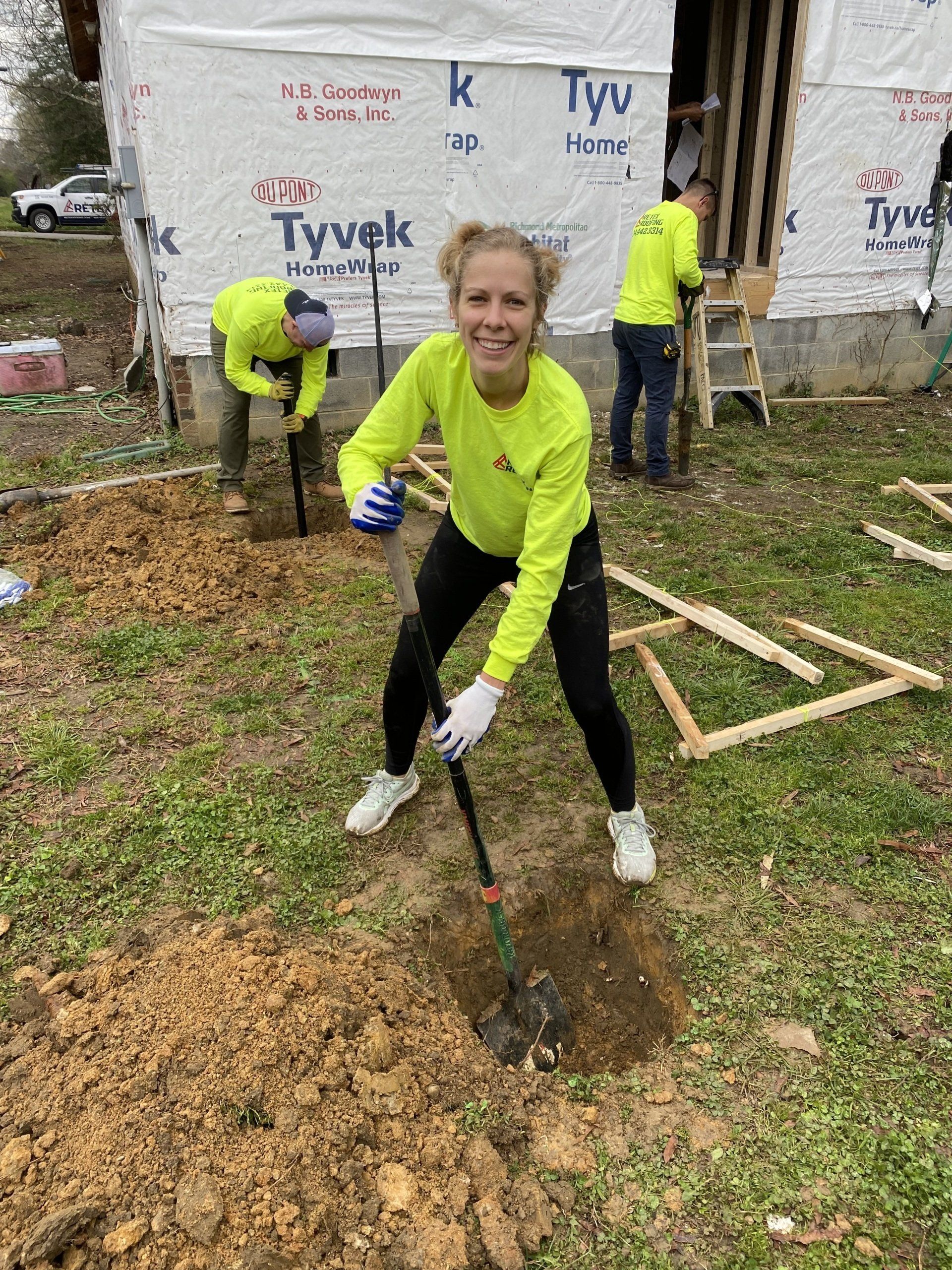 Image of RETEX's Katelyn Lewis volunteering with Richmond Habitat for Humanity, digging a hole for a foundation post.