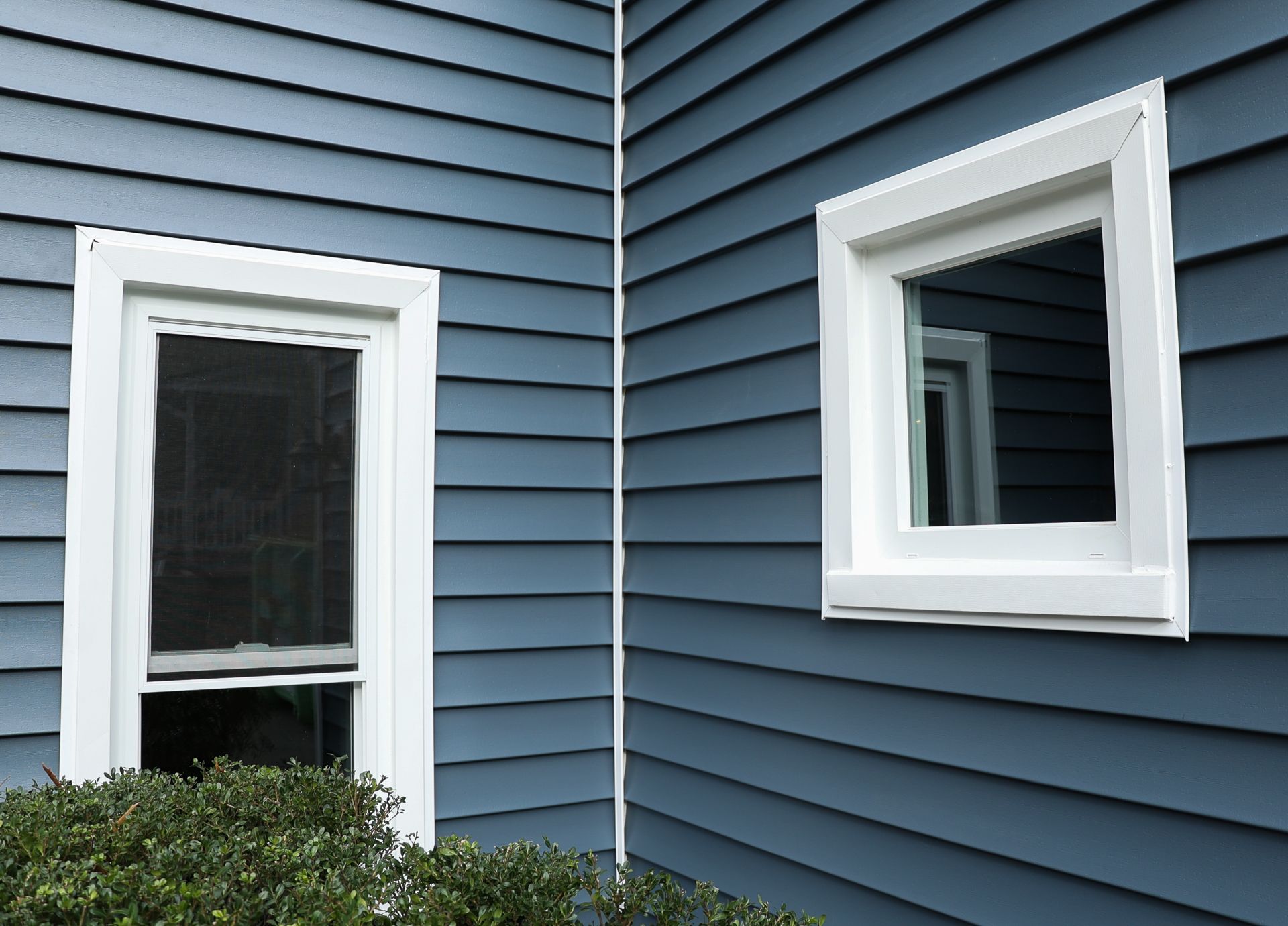 Close-up image of two windows with new siding on a North Chesterfield VA home that RETEX replaced in 2022.