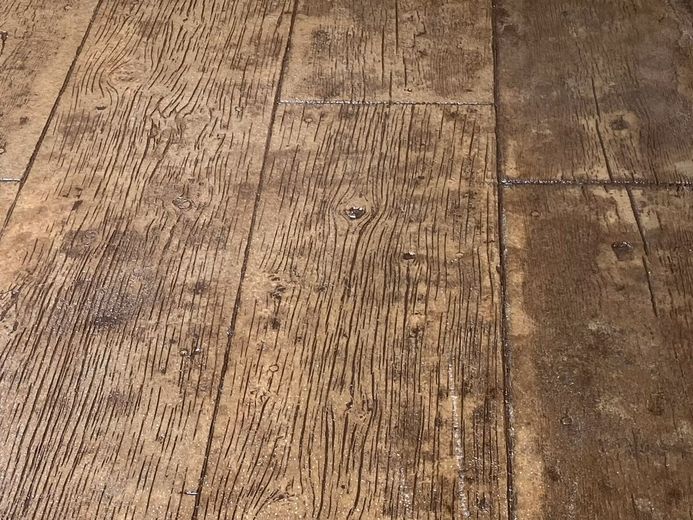 Close-up of worn wooden floorboards with scratches and dark stains