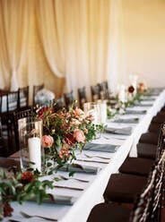 There is a candle in a glass vase on the table.