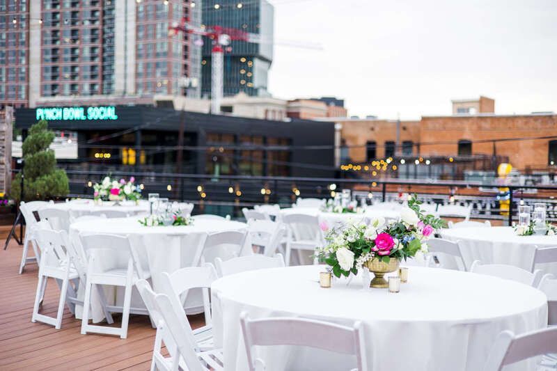 A bunch of tables and chairs are set up for a wedding reception.