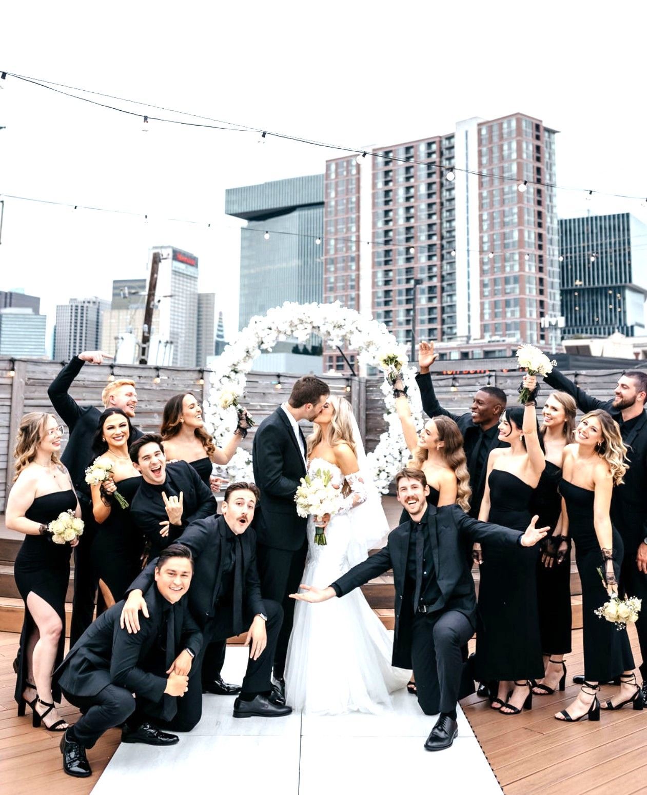 A bride and groom are posing for a picture with their wedding party.