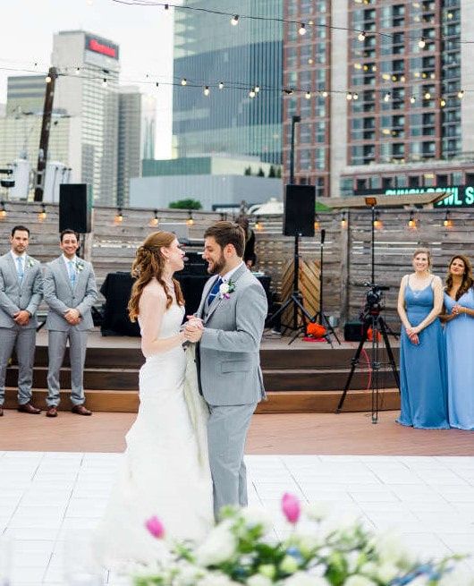 A bride and groom are dancing on a dance floor at their wedding reception.