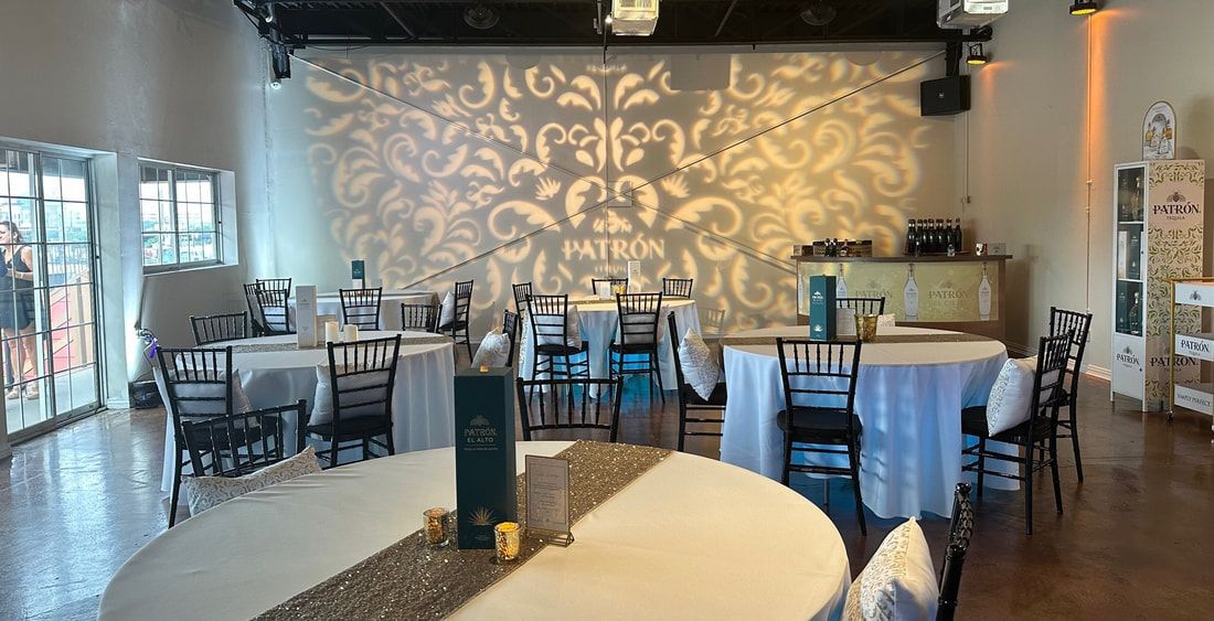 A large room with tables and chairs set up for a wedding reception.