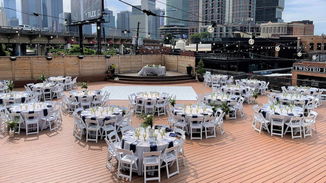 There are a lot of tables and chairs set up for a wedding reception.