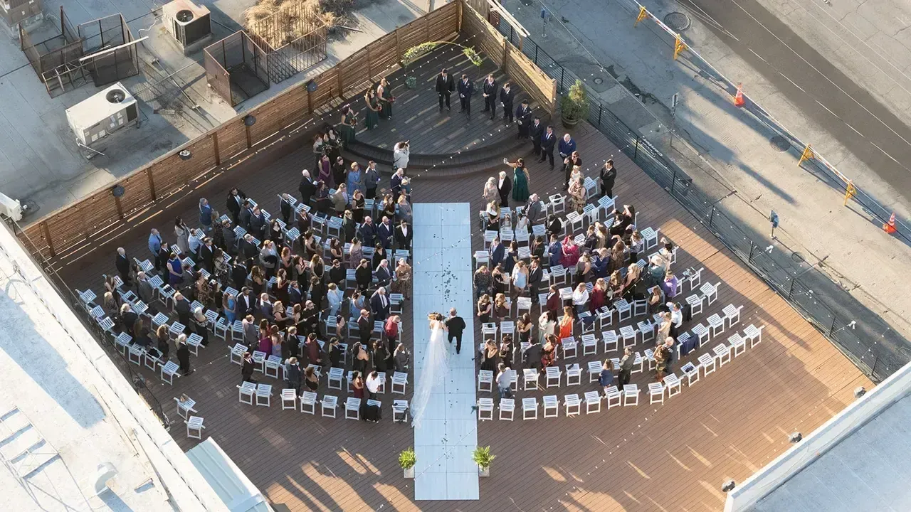 An aerial view of a wedding ceremony on a rooftop.