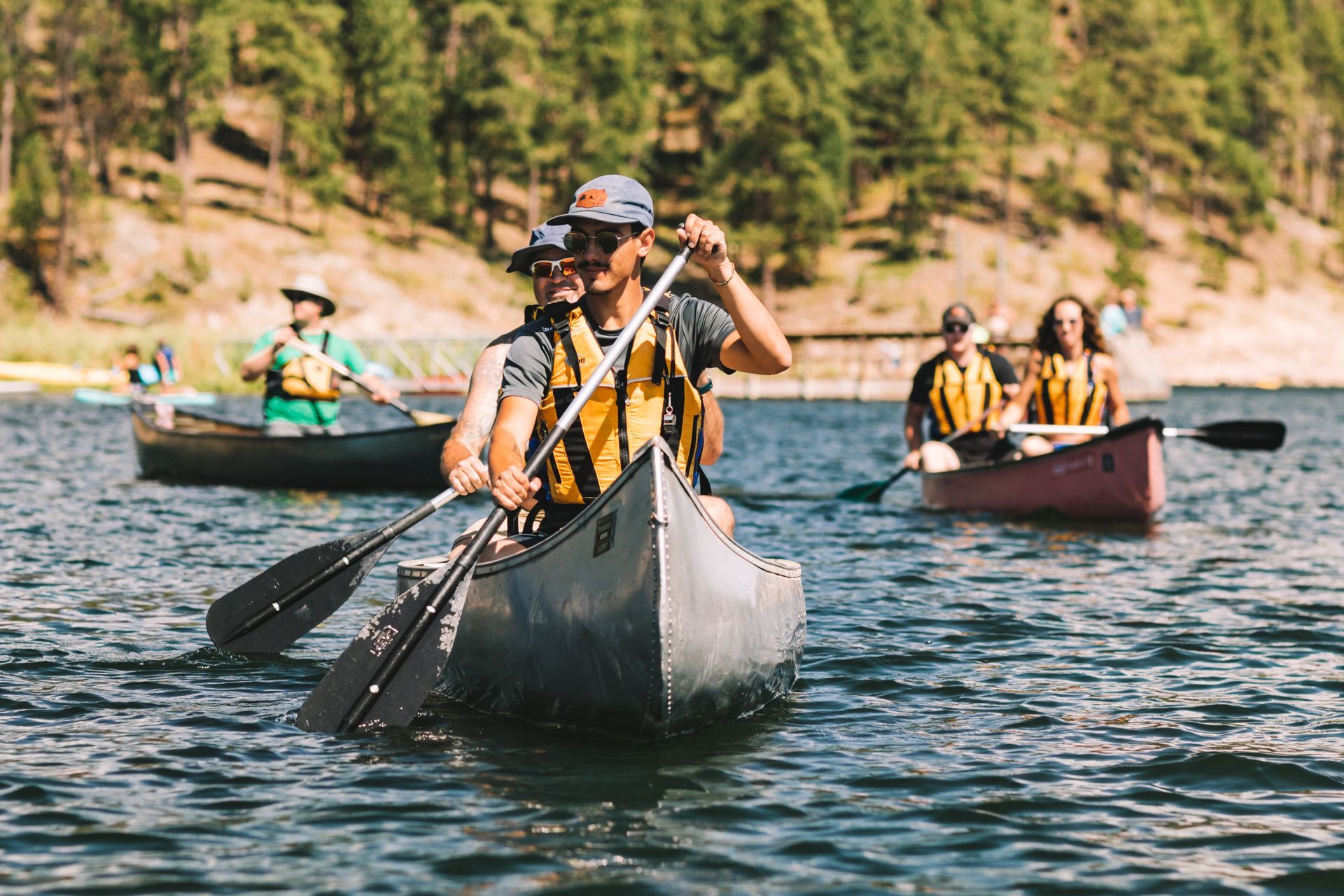 A group of people are paddling canoes on a lake.