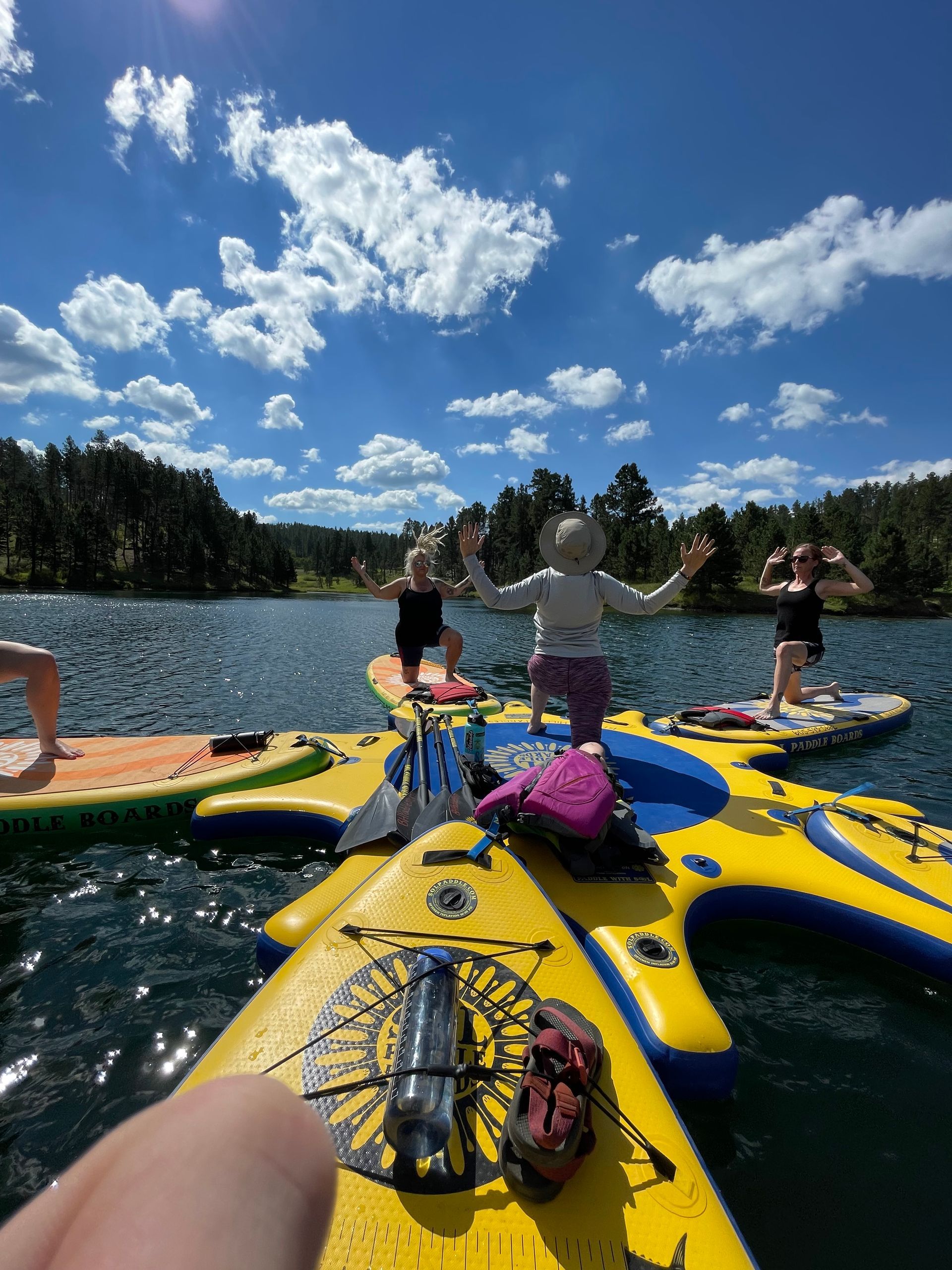A group of people are doing yoga on rafts in the water.