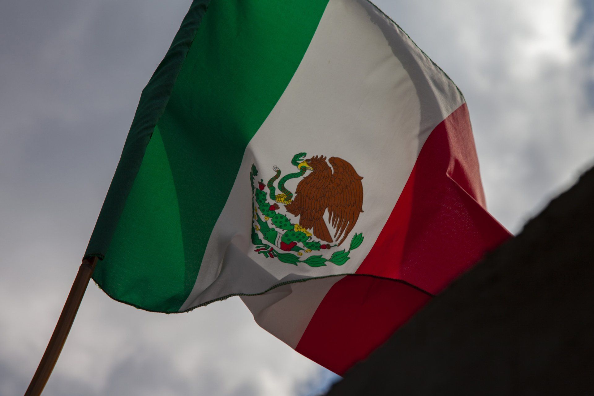 Bandera mexicana ondeando en un asta de bandera en una casa mexicana concepto del día de la independencia de méxico Bandera mexicana ondeando en un asta de bandera en una casa mexicana concepto del día de la independencia de méxico