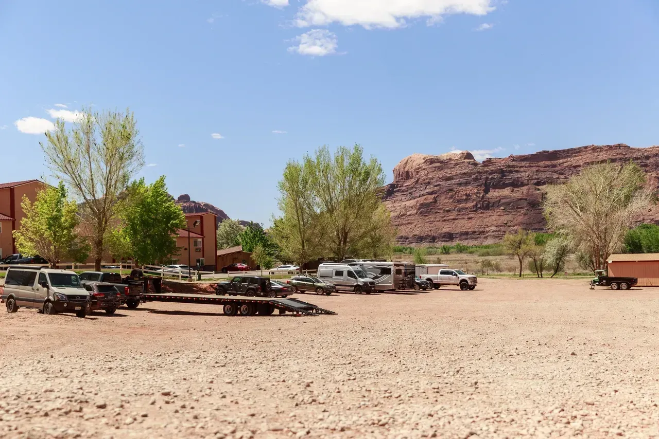 A lot of vehicles are parked in a desert area