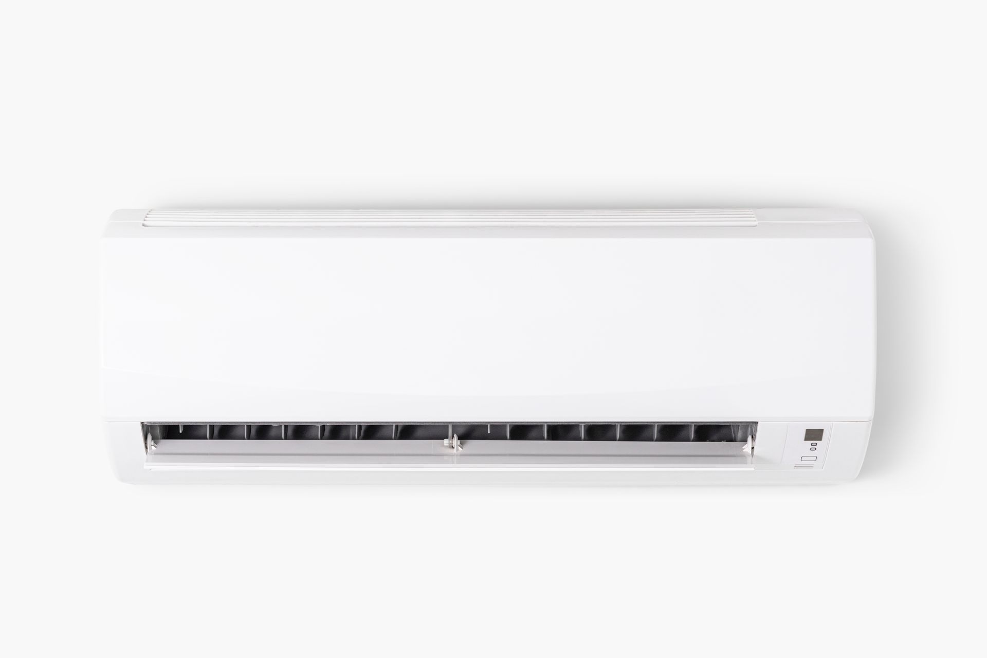 A white air conditioner is hanging on a white wall.