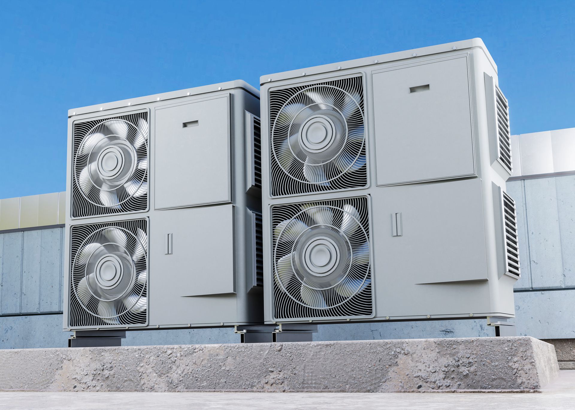 Two air conditioners are sitting on top of each other on the roof of a building.