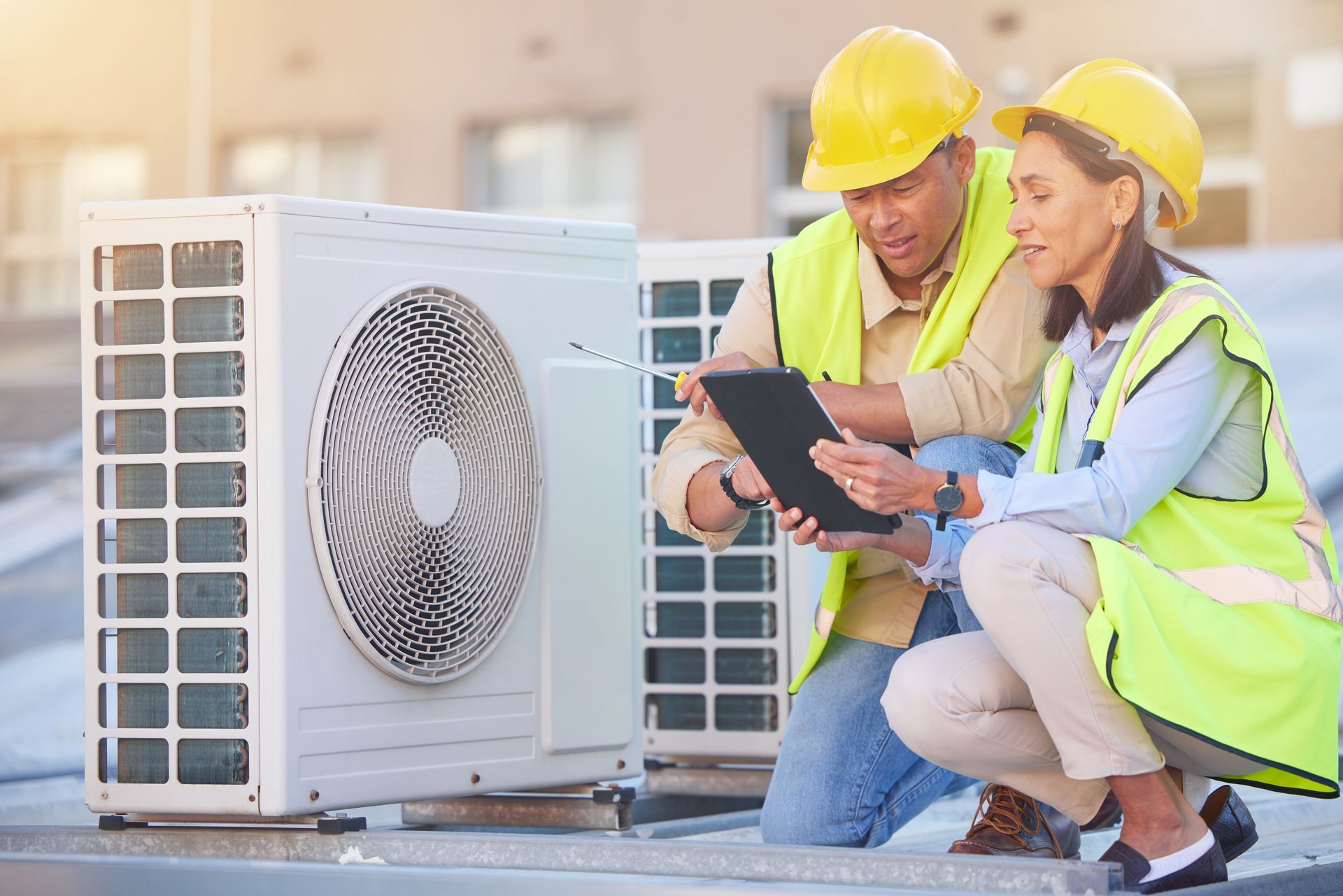 A man and a woman are looking at a tablet next to a fan.
