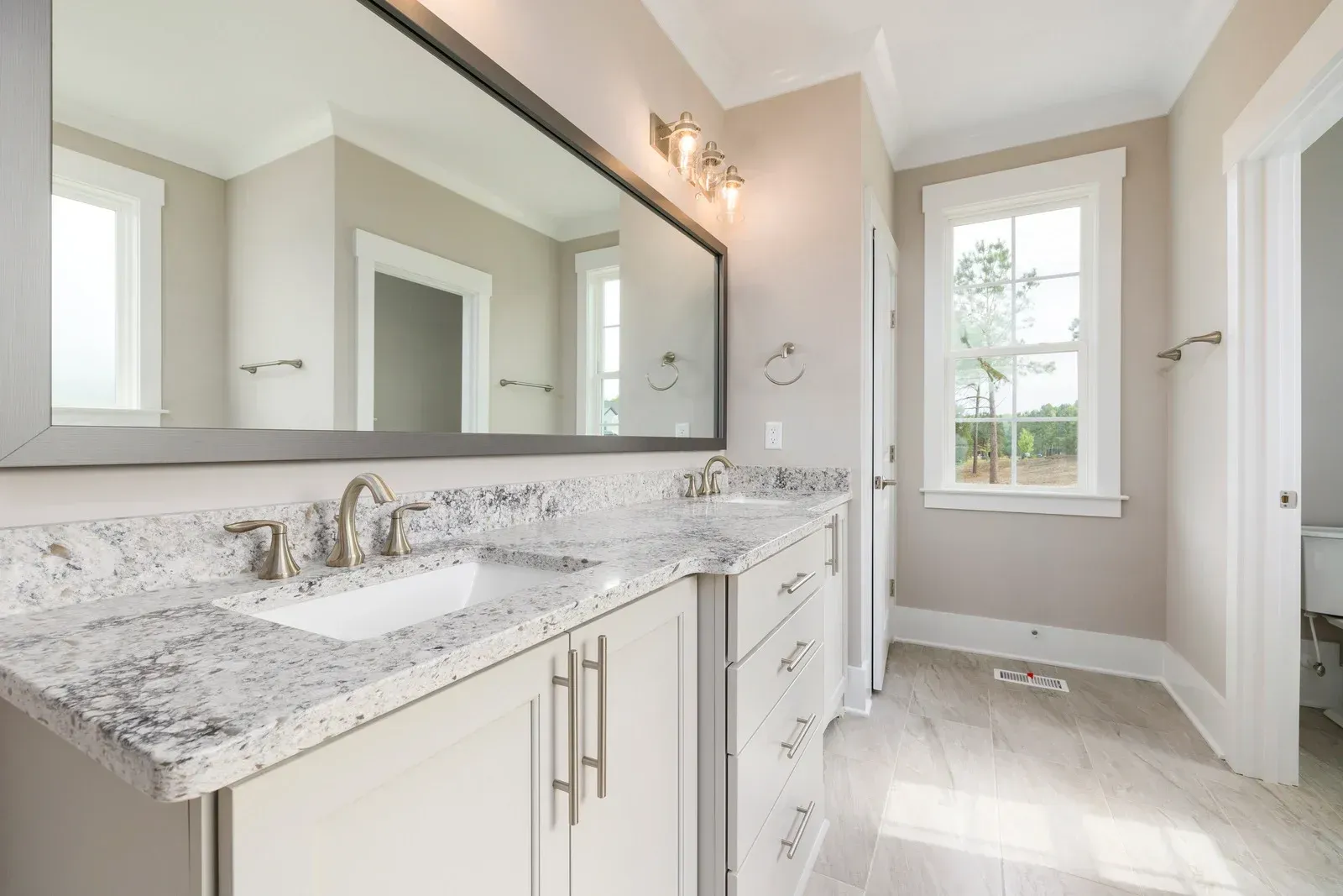 A bathroom with two sinks and a large mirror.