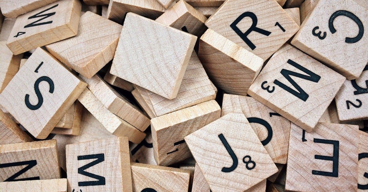 A pile of wooden scrabble tiles with letters on them