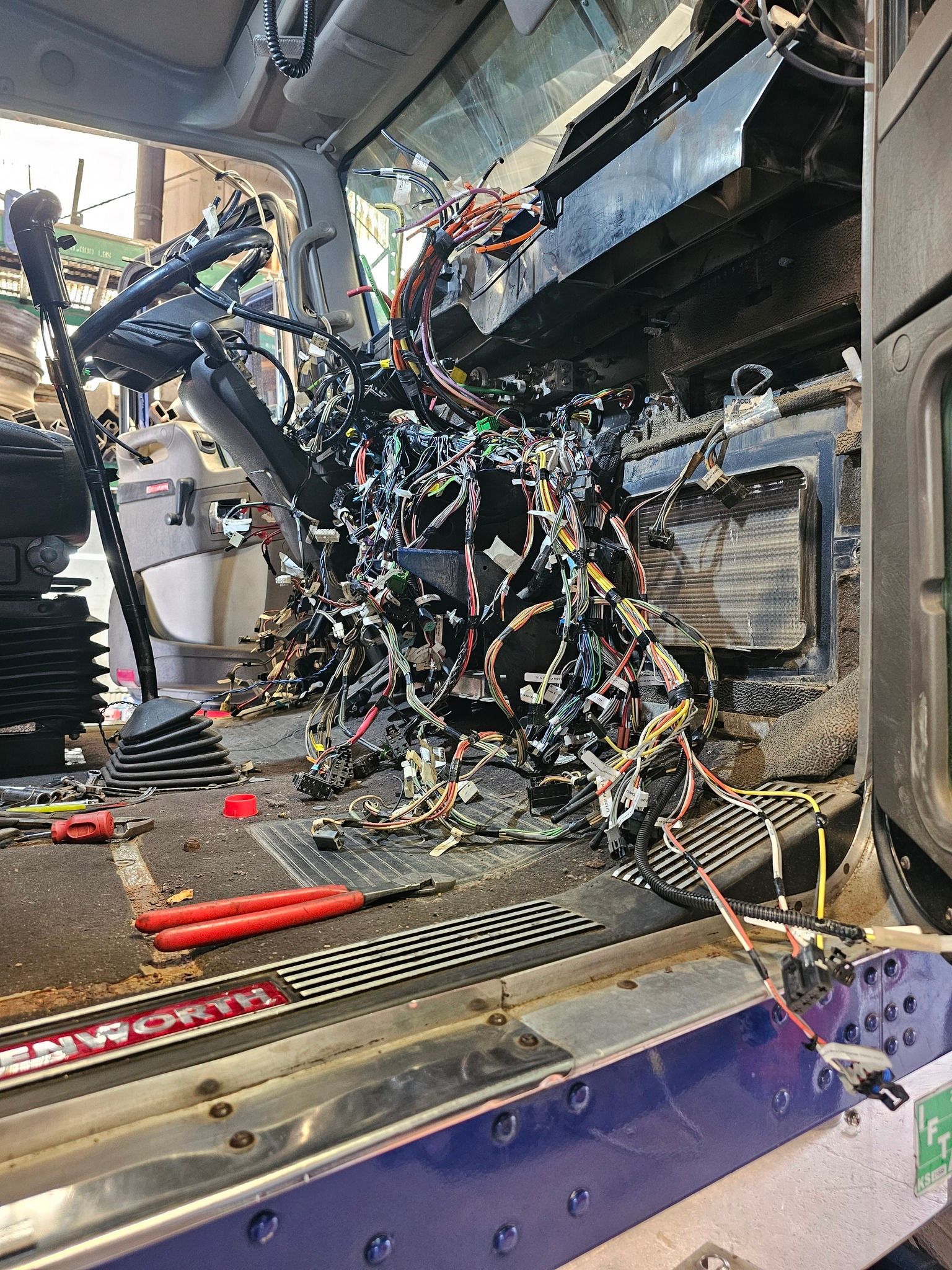 Damaged car interior with shattered dashboard and tangled wires after a crash