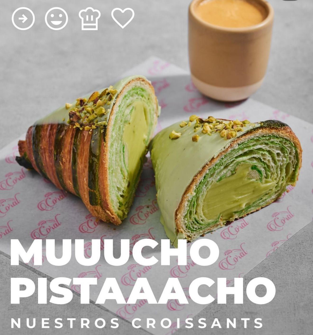 Croissant de pistacho abierto, con relleno verde, junto a una taza de café. Texto: 