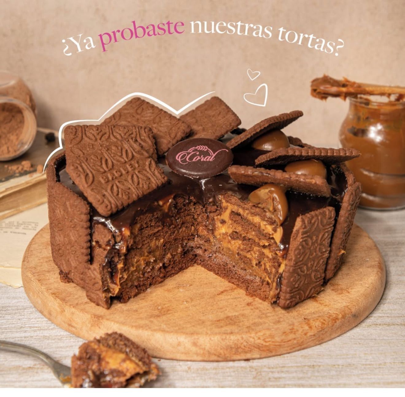 Pastel de chocolate con galletas, con el relleno visible, sobre una tabla de madera. Texto: 