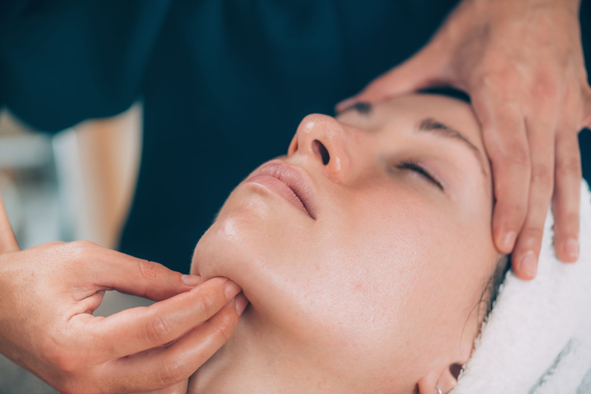 A woman is getting a facial massage at a spa.