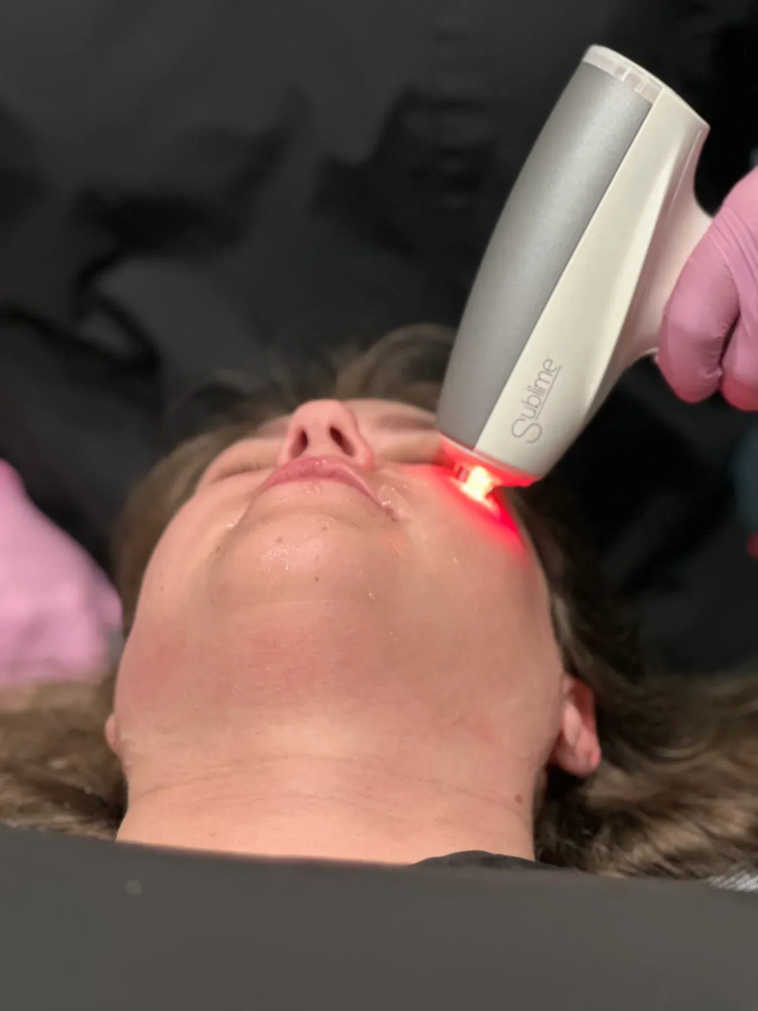 A woman is getting a cavitation treatment on her leg.