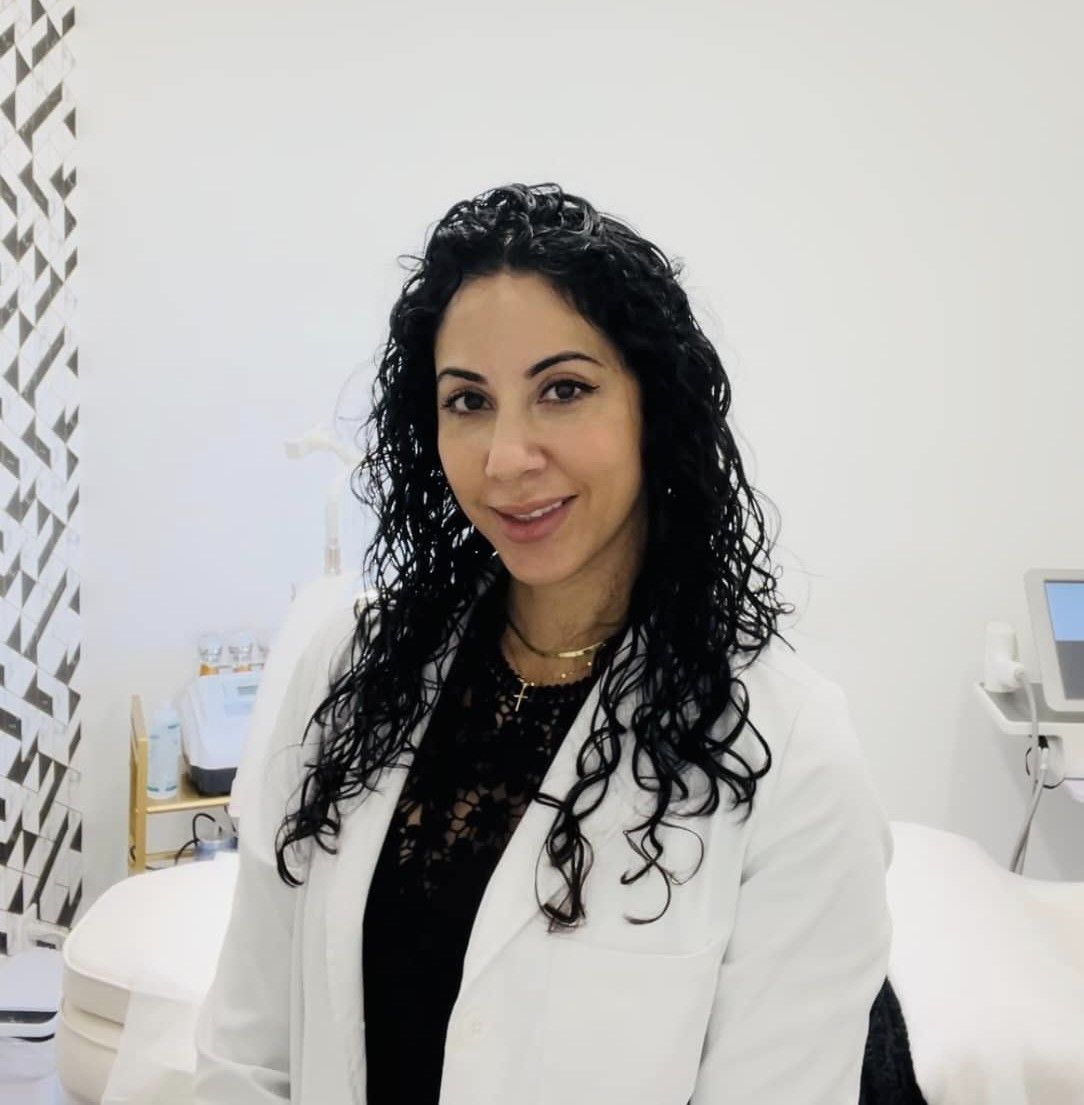 A woman with curly hair wearing a white lab coat