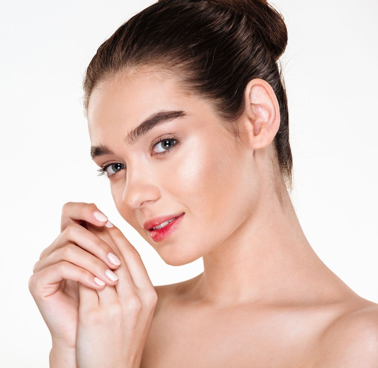 A close up of a woman 's face with her hair in a bun