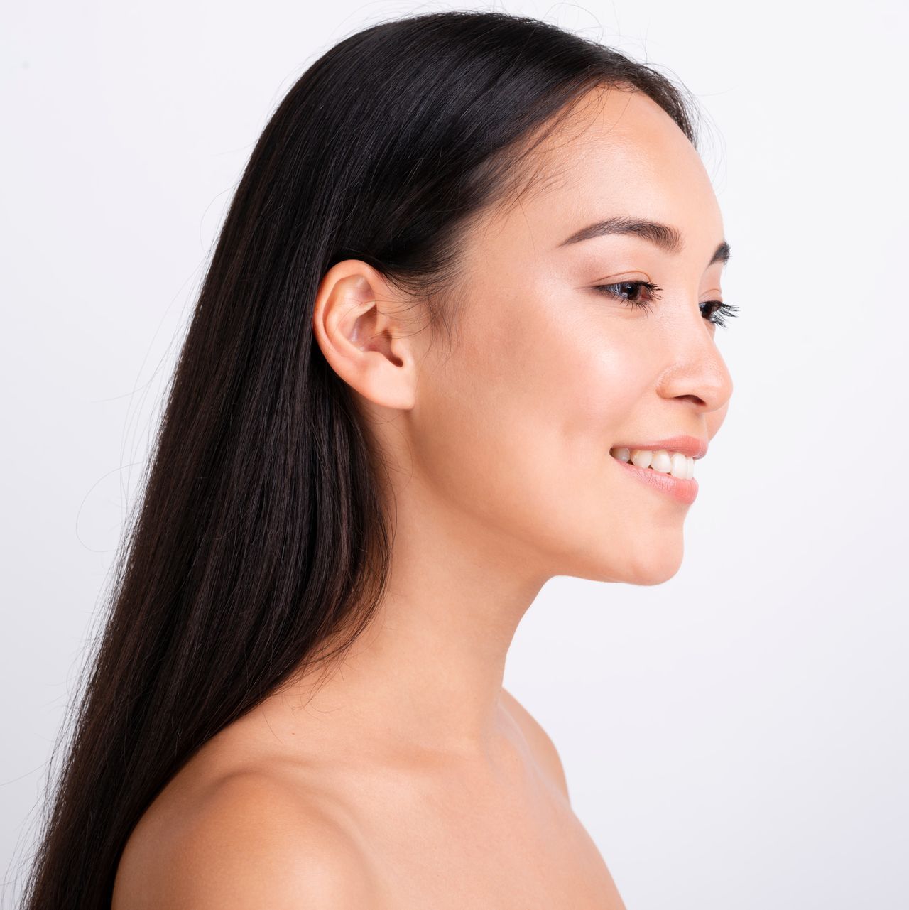 A woman with long hair is smiling and looking at the camera.