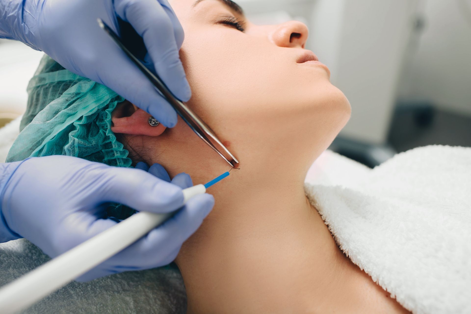 A woman is getting a laser treatment on her neck.