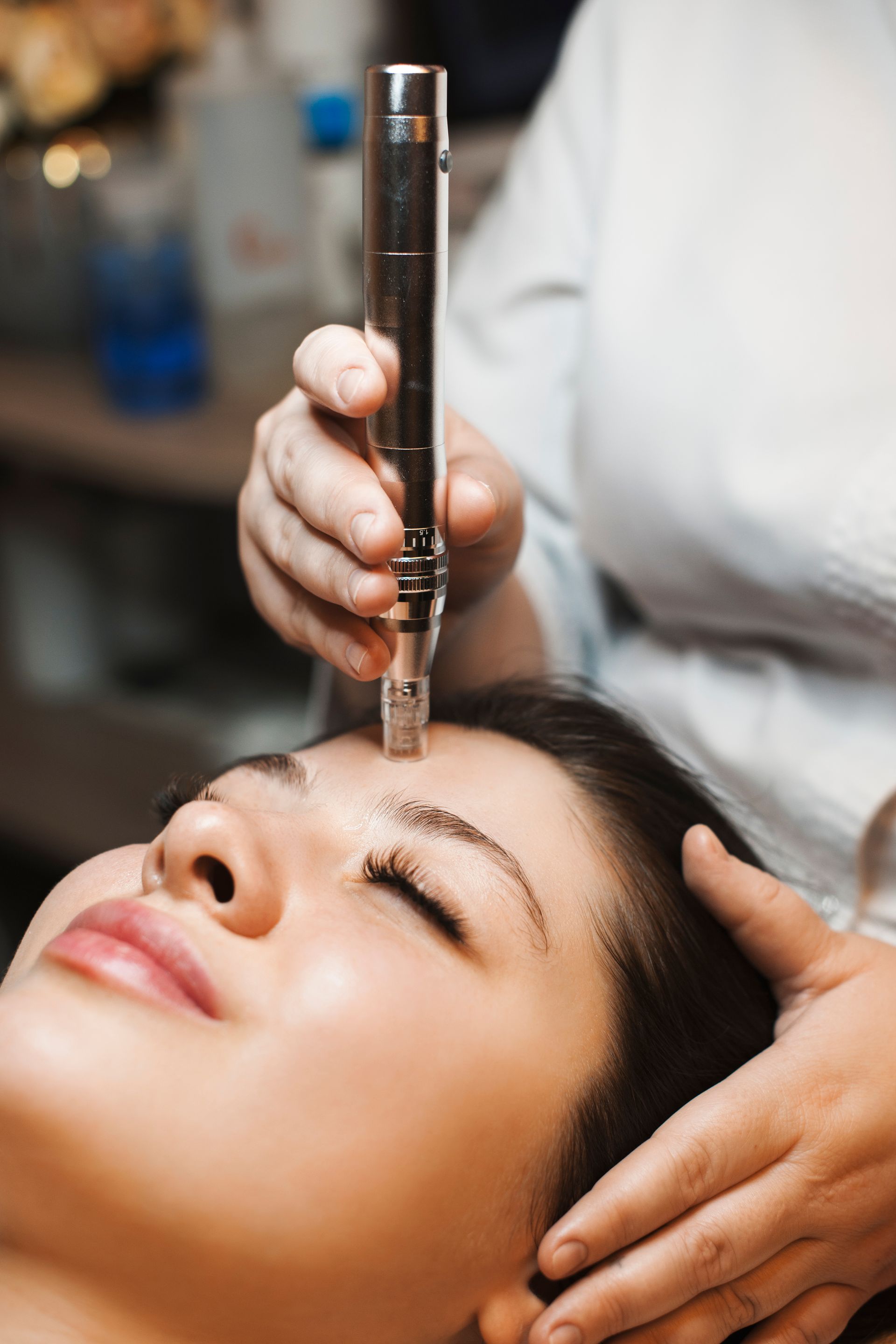 A woman is getting a facial treatment with a machine on her face.