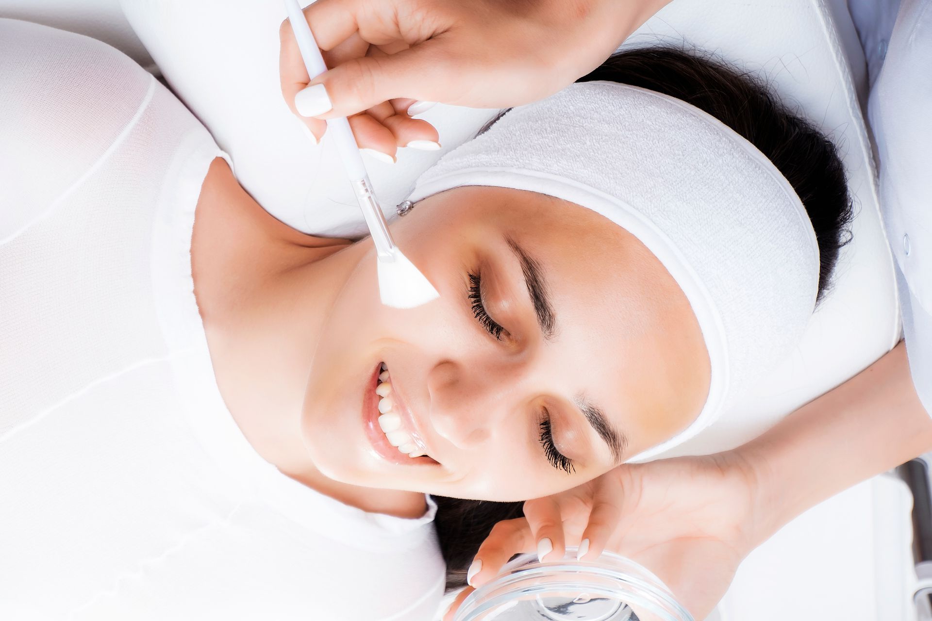 A woman is getting a facial treatment at a beauty salon.
