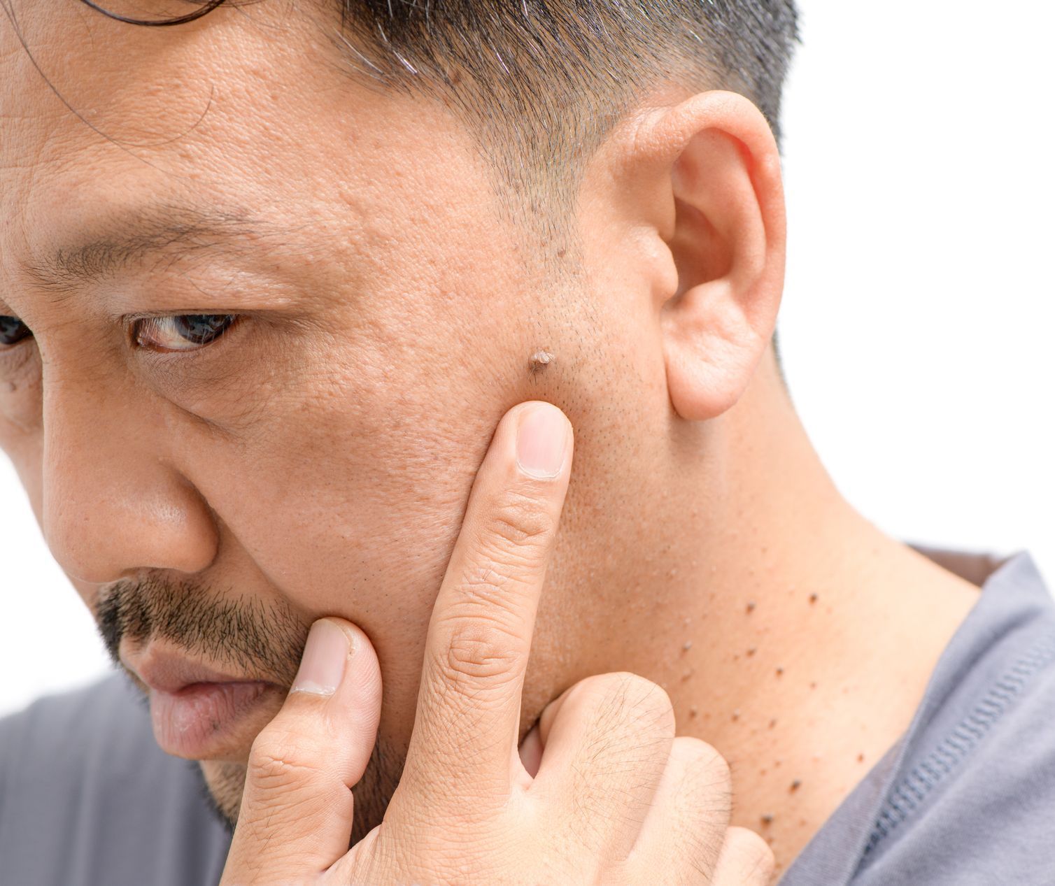 A close up of a man 's face with his finger on his chin.