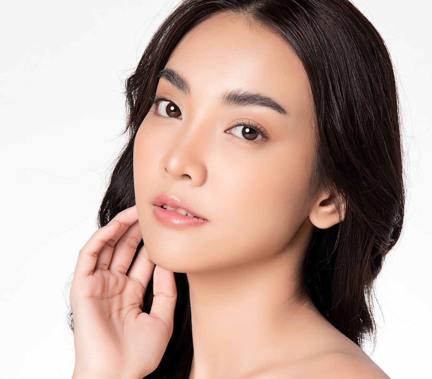 A close up of a woman 's face with her hand on her face.