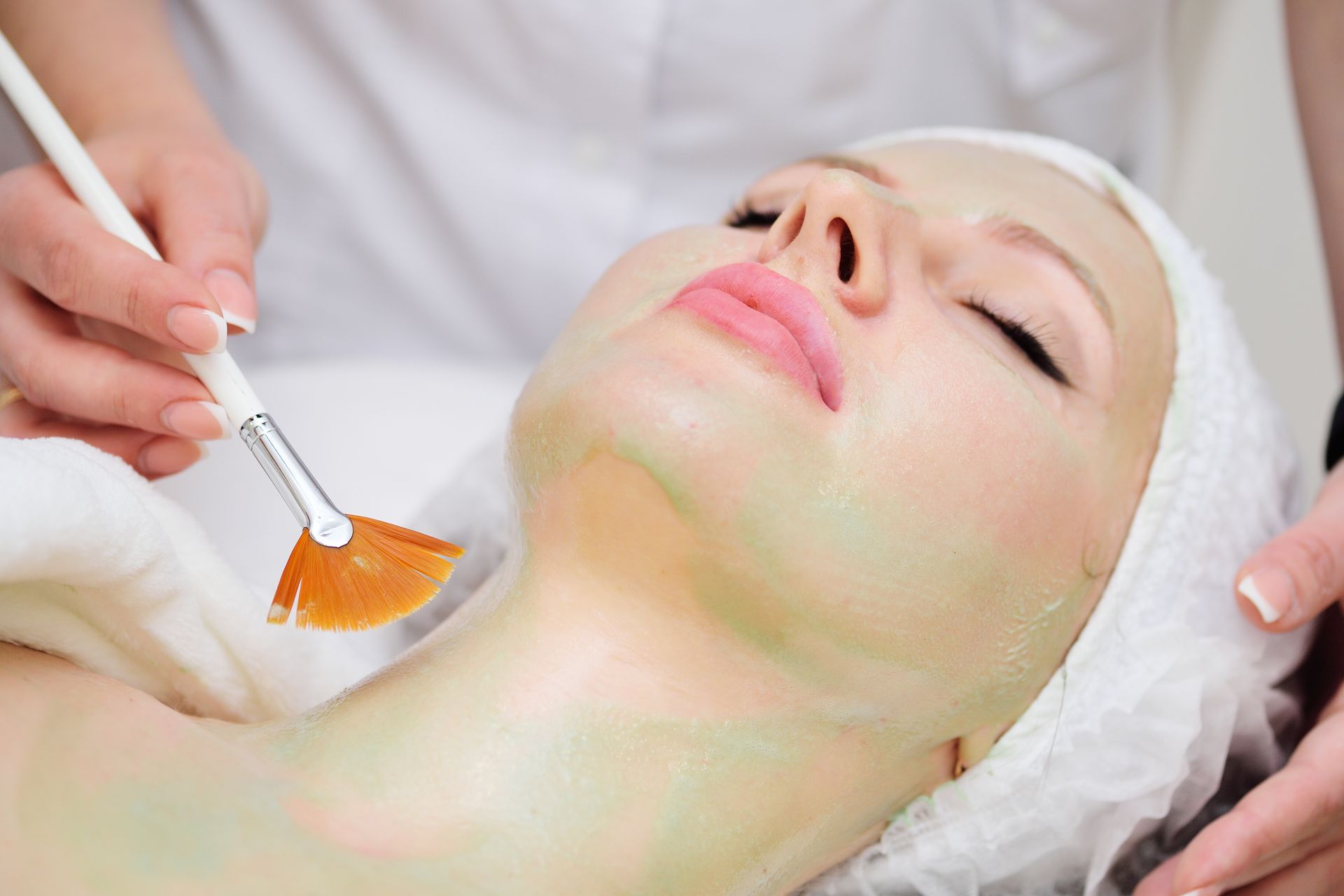 A woman is getting a facial treatment at a spa.