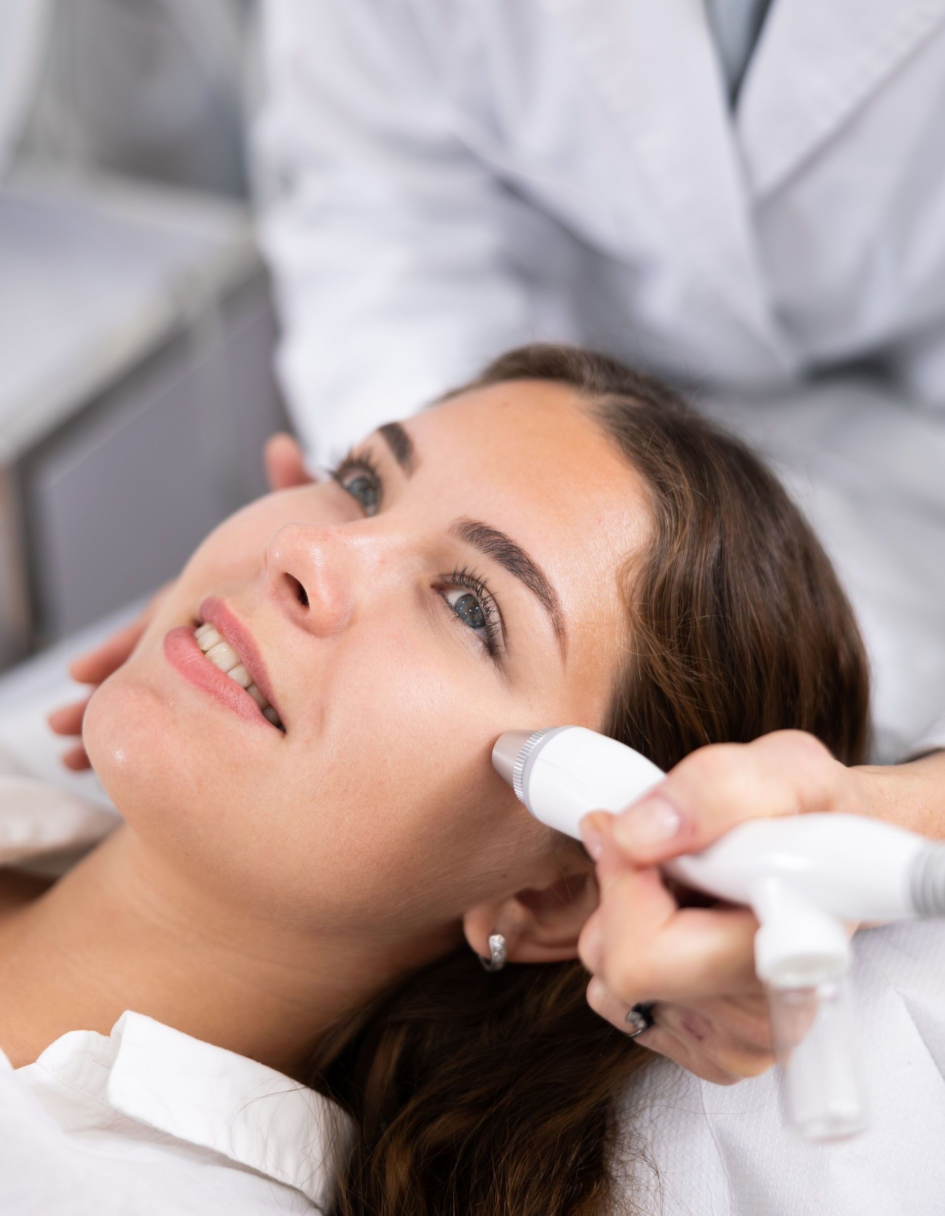 A woman is getting a facial treatment at a beauty salon.