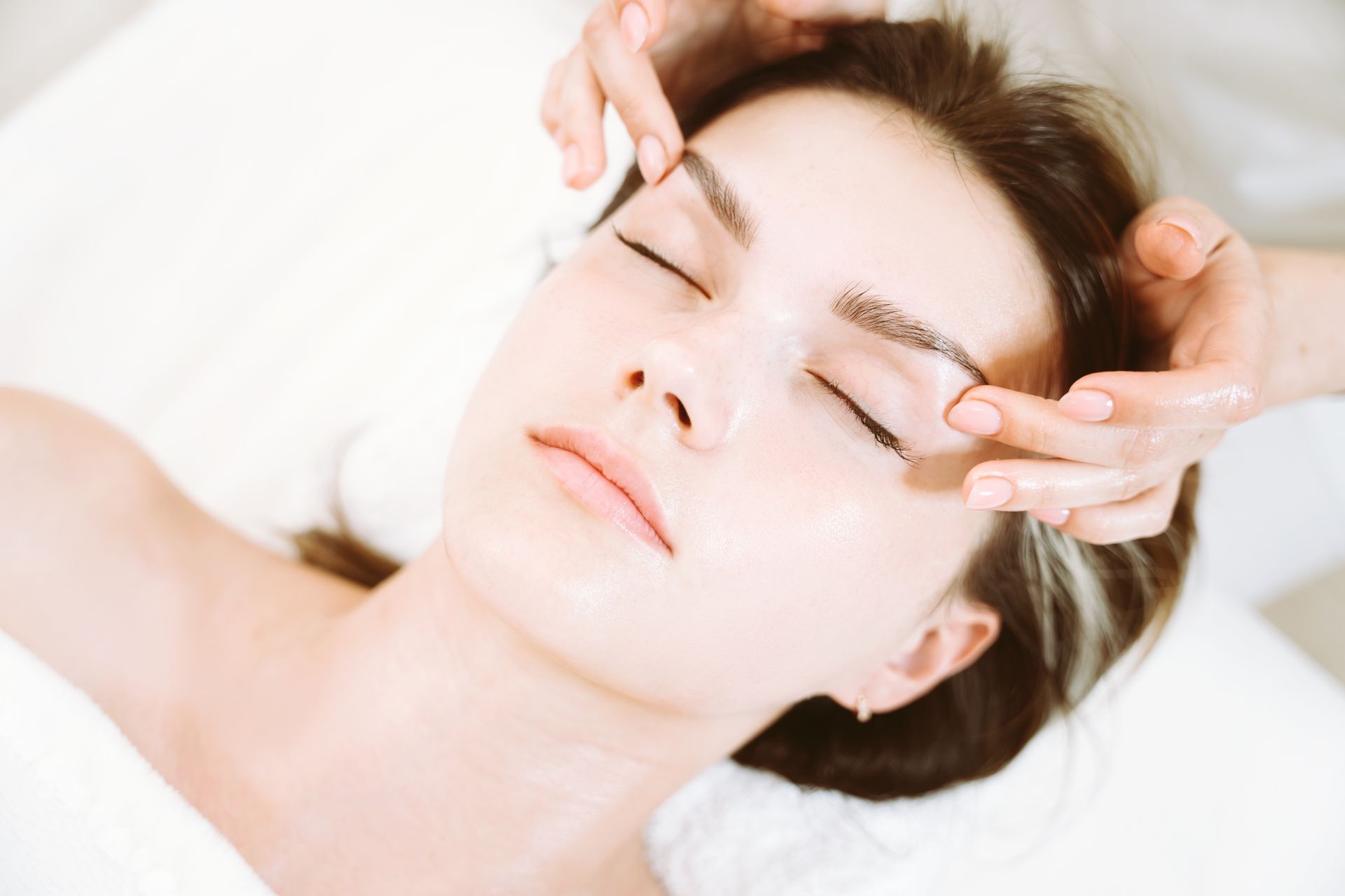A woman is getting her eyebrows waxed in a beauty salon.