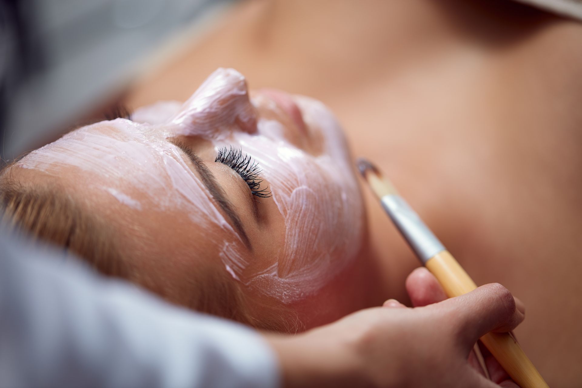 A woman is getting a facial treatment at a spa.