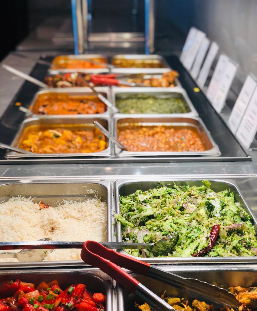 Food buffet: Various Indian dishes in metal trays, including rice, curries, and salads.