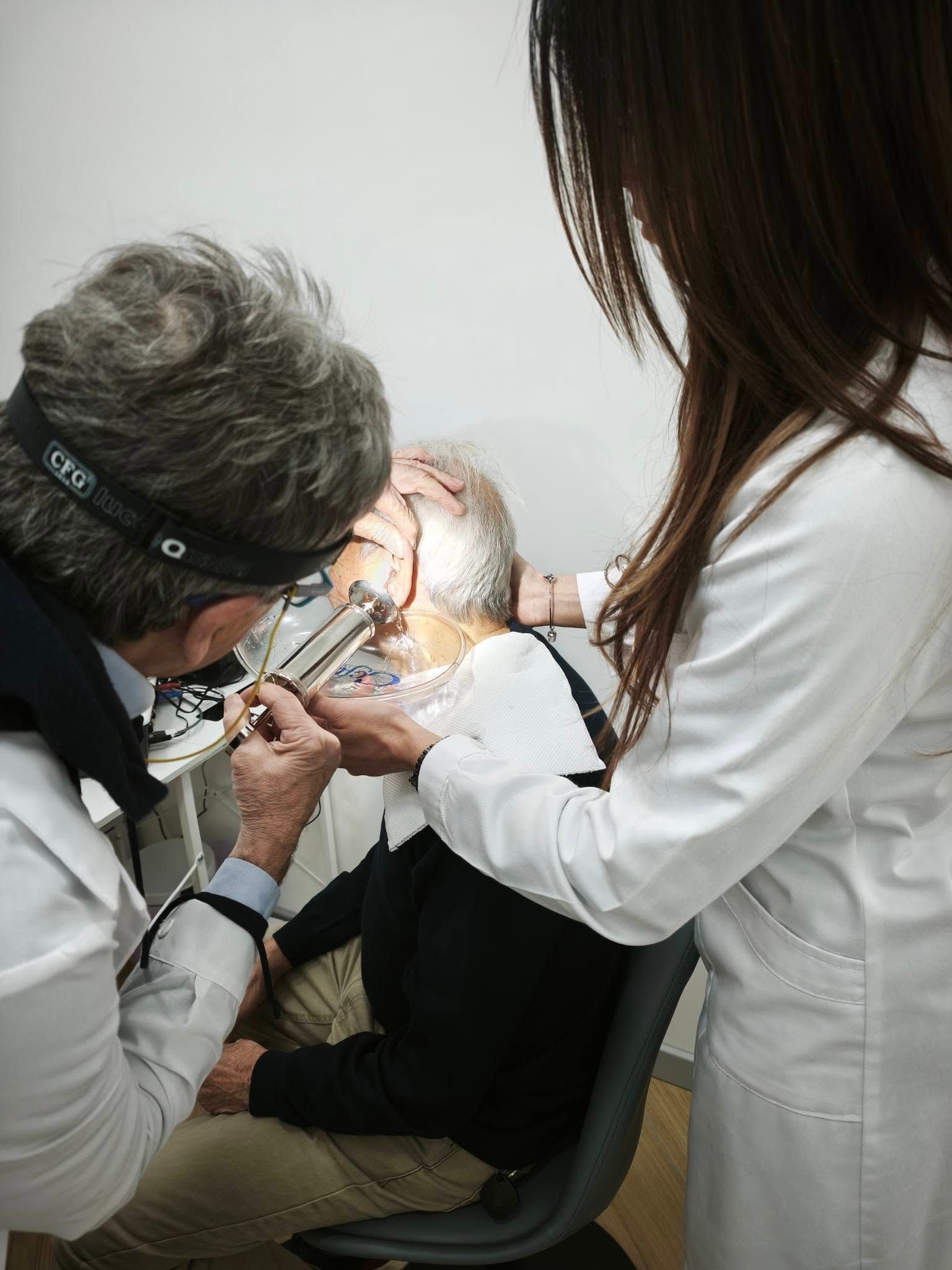 Donna con le cuffie sottoposta a un test dell'udito con un audiologo in una clinica.
