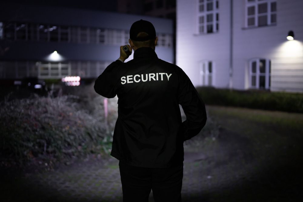 A Security Guard in Dark Uniform Patrolling at Night — Clinton Security Services In Grafton, NSW