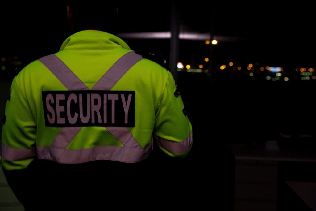 Security Guard in a Yellow Safety Vest Guarding at Night — Clinton Security Services In Armidale, NSW