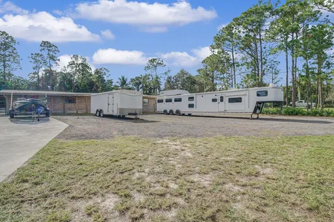 A couple of trailers are parked in front of a house