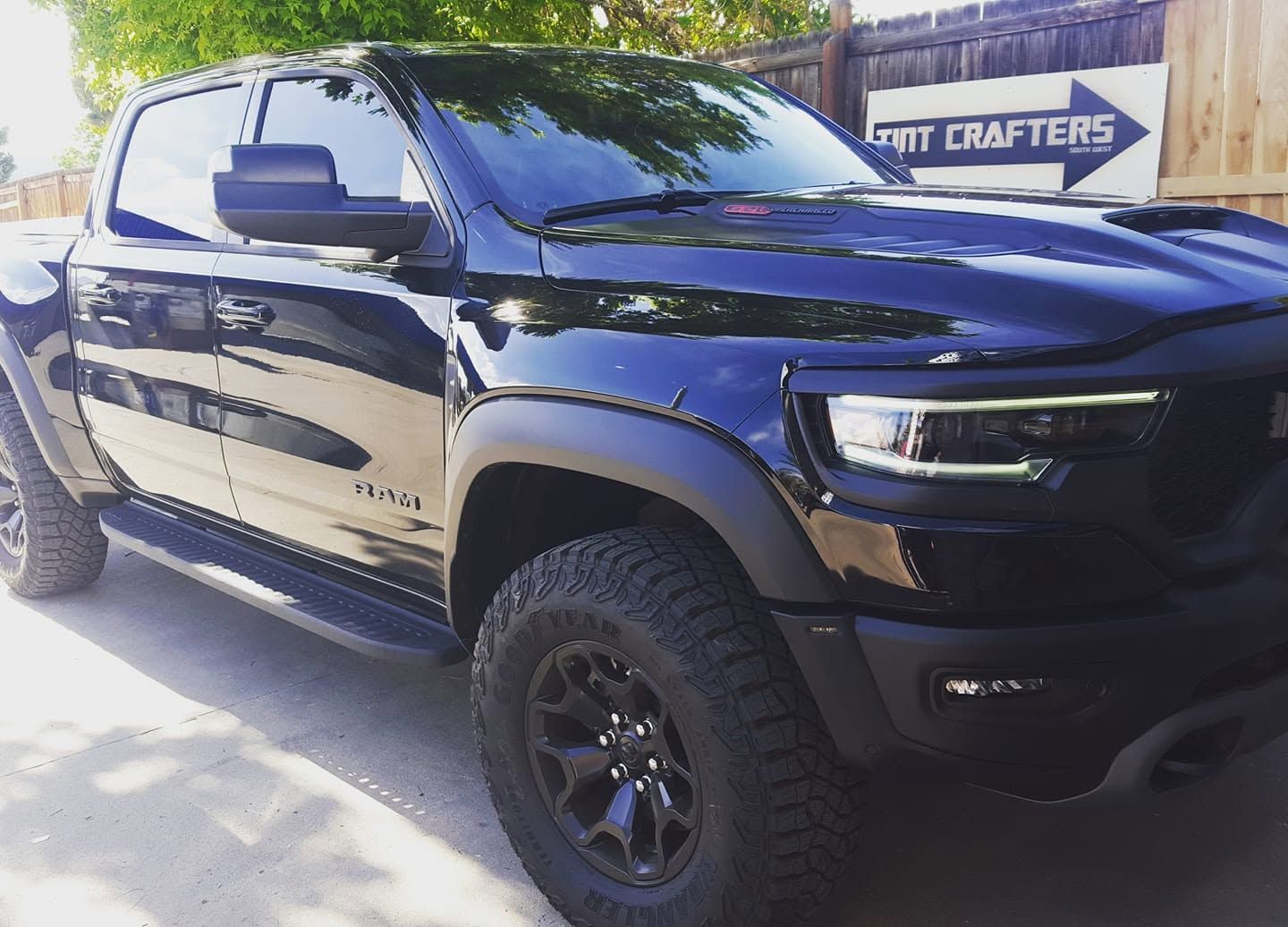Black pickup truck parked outdoors in daylight, with custom wheels and glossy paint