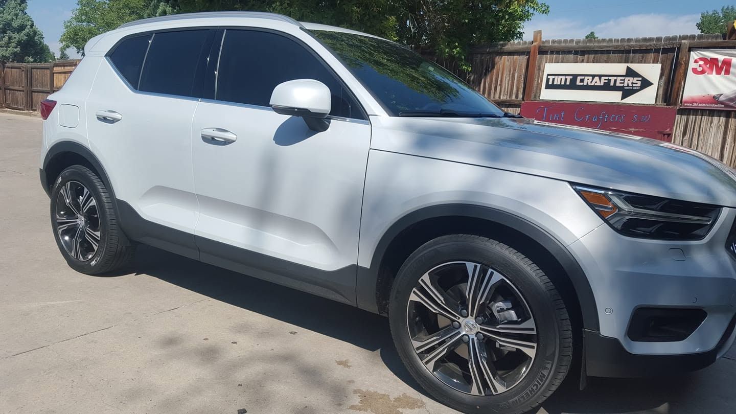 White SUV parked outdoors on a sunny day, side view with black wheels.