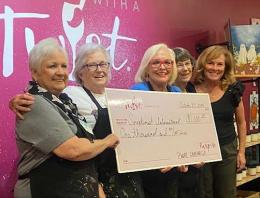 Five people holding a large donation check for $1,000 for