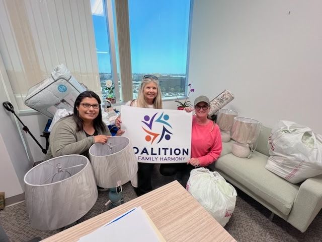 Three people in an office hold a sign for 
